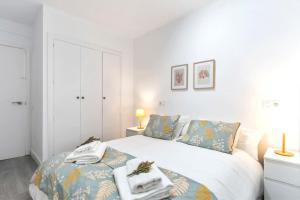 希洪Apartamento Marqués de Urquijo的白色卧室,配有带毛巾的床