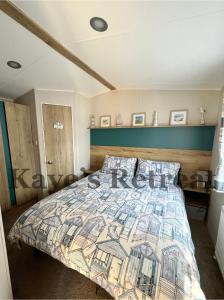 纽基Kayes Retreat Three bed caravan Newquay Bay Resort Quieter area of park的一间卧室配有一张带五颜六色被子的床