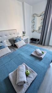美洲海滩Torres Del Sol Luxury Las Americas的一张带毛巾的蓝色床和两颗苹果