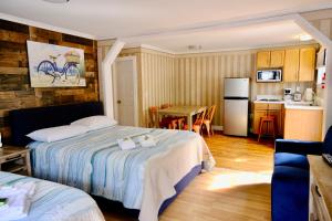 旧奥查德比奇老果园海滩兰迪酒店加小屋的一间带两张床的卧室和一间带桌子的厨房