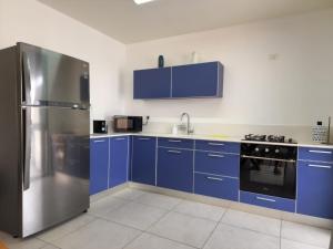 马格达拉Magdala Infront Sea of Galilee and Mount Harbel的厨房配有蓝色橱柜和不锈钢冰箱
