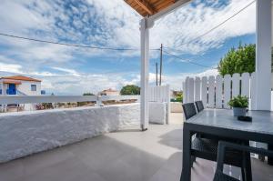 迈加洛丘里Anzuelo Apartments的庭院配有桌椅和白色围栏。