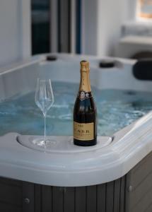 迈加洛丘里Anzuelo Apartments的浴缸里的一瓶香槟和一杯葡萄酒