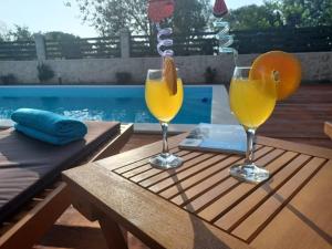 罗佐瓦克Apartment Karla SNB的游泳池畔桌子上放两杯橙汁
