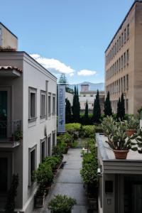 庞贝论坛酒店的两座种植盆栽植物的建筑之间的人行道