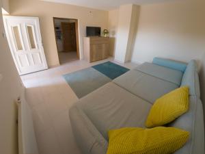 福纽德Martour-ház的客厅配有带黄色枕头的沙发