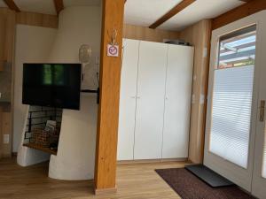 多恩比恩Tiny Haus Dornbirn的客厅配有大型白色橱柜和电视
