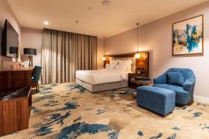 塔伊夫فندق رويال دايموند الطائف的酒店客房,配有一张床和一张蓝色椅子