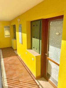 菲夏诺Residenze Salernitane的一间设有黄色墙壁和滑动玻璃门的房间
