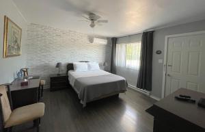 蒙克顿奥贝格雷斯特维汽车旅馆的一间卧室设有一张床和砖墙