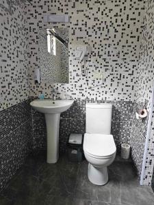 谢赫维蒂利Villa Story Hotel的浴室配有白色卫生间和盥洗盆。