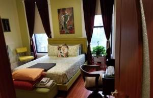 纽约Spacious Fully Furnished Harlem Apartment Near Morningside Park的一间卧室,卧室里配有一张床,狗坐在床上