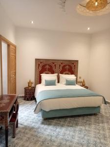 索维拉Riad Mellah的一间卧室配有一张大床和一个吊灯。