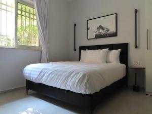 耶路撒冷White Moon Inn的一间卧室配有一张带白色床单的床和一扇窗户。
