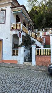 欧鲁普雷图Casa do Chá Ouro Preto的大楼前有楼梯的房子