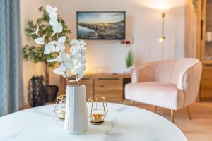 加兹尤瑟多姆Apartment "Strandaster" - Haffresidenz的一张桌子上花的白色花瓶