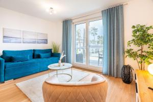 加兹尤瑟多姆Apartment "Strandaster" - Haffresidenz的客厅配有蓝色的沙发和桌子