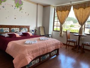 奥塔瓦洛Hostal Arauco的一间卧室配有一张床,上面有两条毛巾