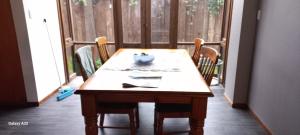 陶朗加City Bungalow的一张木桌,房间配有椅子和窗户