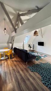 欧塞尔RhizHome - Coeur de ville, appartement spacieux的客厅配有黑色沙发和桌子