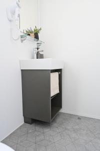德拉格O'LIVE PREMIUM Mobile Home的白色墙壁上设有水槽的浴室