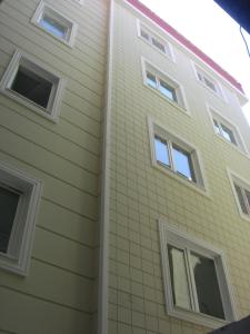 特拉布宗Downtown Merkez Suites的建筑的侧面设有白色窗户