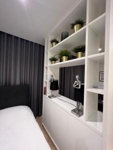 New BedfontLondon LuXXe Suites & Apartments - London Heathrow Airport, Terminal 1 2 3 4 5的一间卧室配有床和植物架子