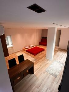 GjakoveStudio Y的一间卧室配有红色的床和一张桌子