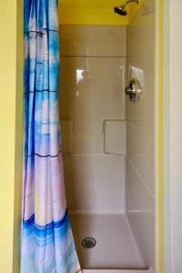 旧奥查德比奇Dock House Inn的浴室里配有带色彩缤纷的淋浴帘的淋浴