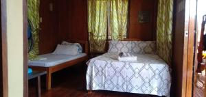 圣维森特Nellie's Tourist Inn- Port Barton的小房间设有一张床和一张桌子