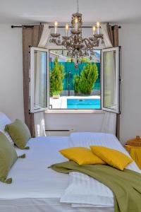 珀德垂那Nudist friendly villa with fence arround pool and garden to relax and enjoy的卧室配有白色的床和窗户。