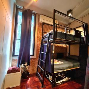 曼谷MEEMAW'S House Hostel的砖墙内带两张双层床的房间