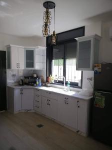 杰里科Al bader villa的厨房配有白色橱柜、水槽和窗户。