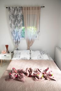 塞奥洛戈斯Livadi house的一间卧室配有一张带粉红色毯子的床和窗户。