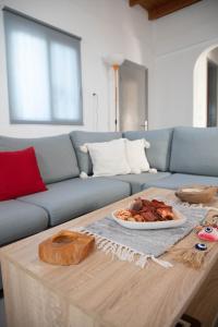 塞奥洛戈斯Livadi house的客厅配有沙发和一张带一盘食物的桌子