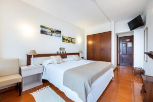 塞勒玛萨勒玛居家酒店的卧室配有一张白色大床和电视。