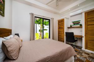 圣克鲁斯Casa Tequila的一间卧室配有一张床、一张书桌和一个窗户。