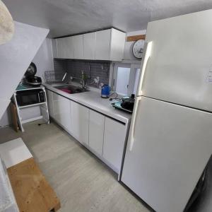 釜山JUN house - Foreign Only的厨房配有白色橱柜和白色冰箱。