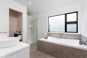 OakuraOakura Beach Front Apartments的白色的浴室设有浴缸和窗户。