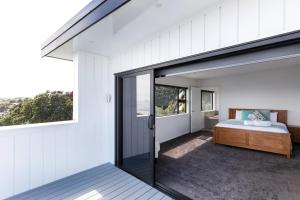 OakuraOakura Beach Front Apartments的一间卧室设有一张床和一个滑动玻璃门