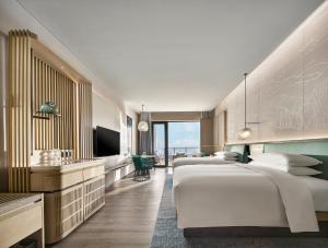 秦皇岛秦皇岛万豪度假酒店的酒店客房设有三张床和电视。