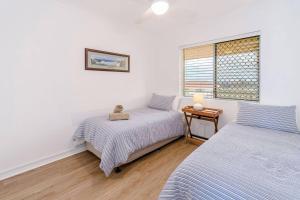 扬巴Pippi Beach Penthouse的一间卧室设有两张床和窗户。