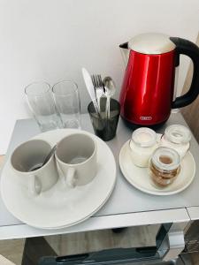鲁德普特Stay In Carlazo - Unlimited WiFi, Solar backup的一张桌子,上面放着两个盘子,一个咖啡壶,一个杯子