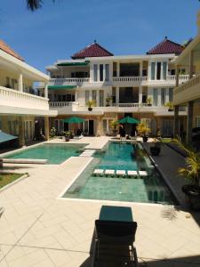 勒吉安巴厘岛庭院公寓及酒店的一座大型建筑,前面设有一个游泳池