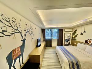 Changhua County晨阳文旅的卧室配有一张床,墙上有一棵树