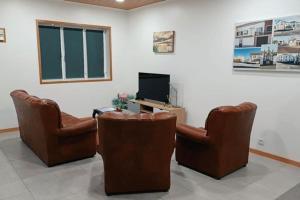 拉日什Cantinho do Cruzeiro Lajes的一间设有两把椅子和电视的等候室