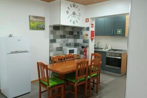 拉日什Cantinho do Cruzeiro Lajes的厨房配有木桌和木椅
