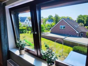 霍尔斯泰因地区诺伊斯塔特FeWo Suite Spaltsberg am Binnenwasser的享有房屋景致的窗户。