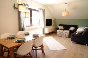 霍尔斯泰因地区诺伊斯塔特FeWo Suite Spaltsberg am Binnenwasser的客厅配有木桌和椅子