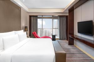 重庆重庆富力艾美酒店的配有一张床和一台平面电视的酒店客房